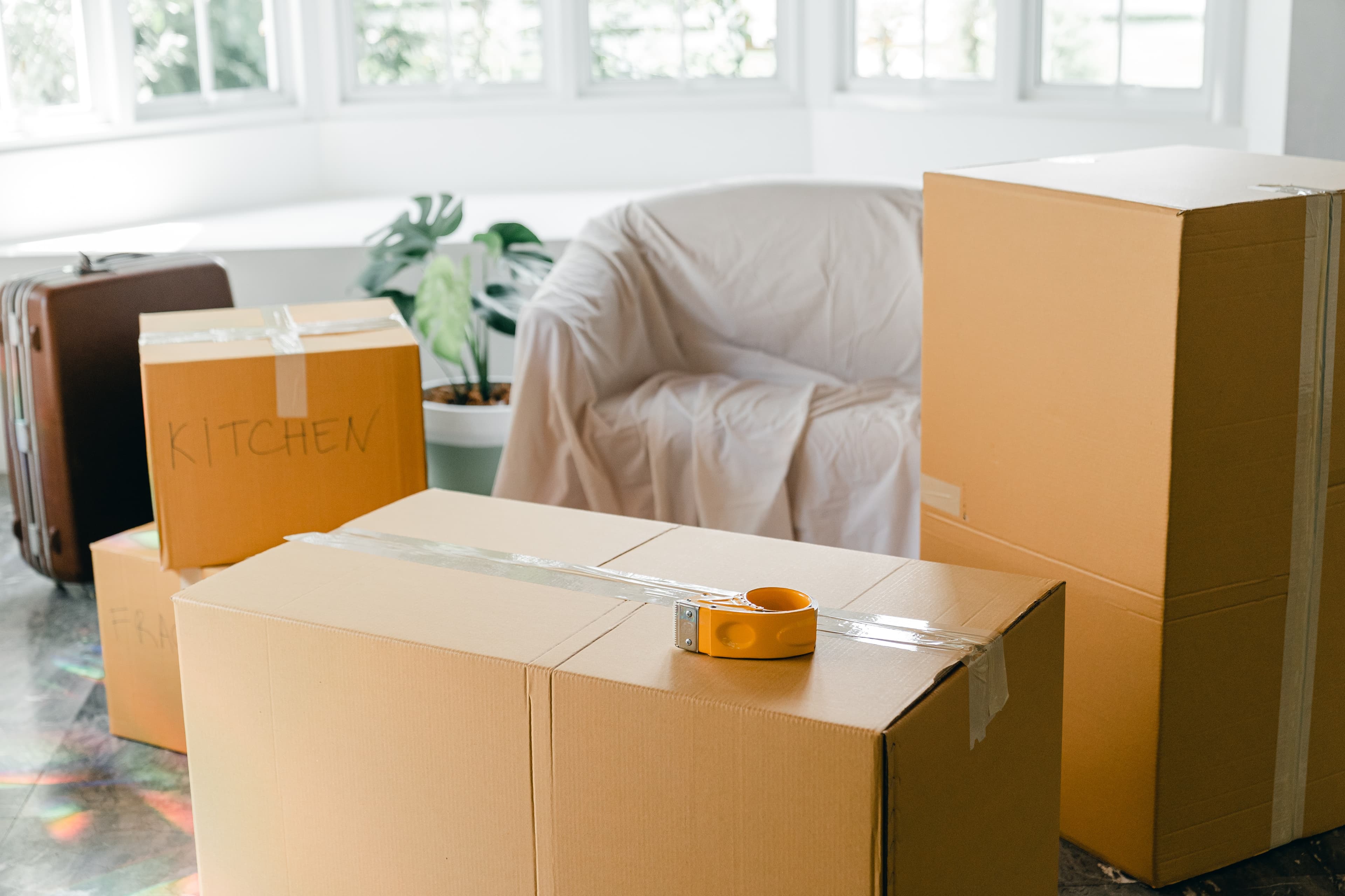 moving boxes and a sofa covered in a sheet in preparation for moving.