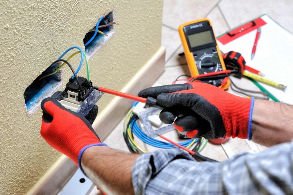 Electrician technician at work with safety equipment on a reside