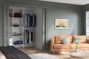 Green bedroom with a closet that has two hanging rods, one atop the other, and shelves